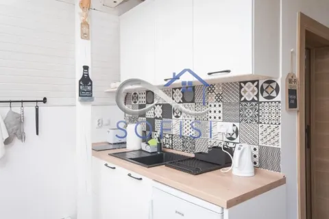 Part of the kitchen with white cabinetry, a sink, and decorative wall tiles. - image 11