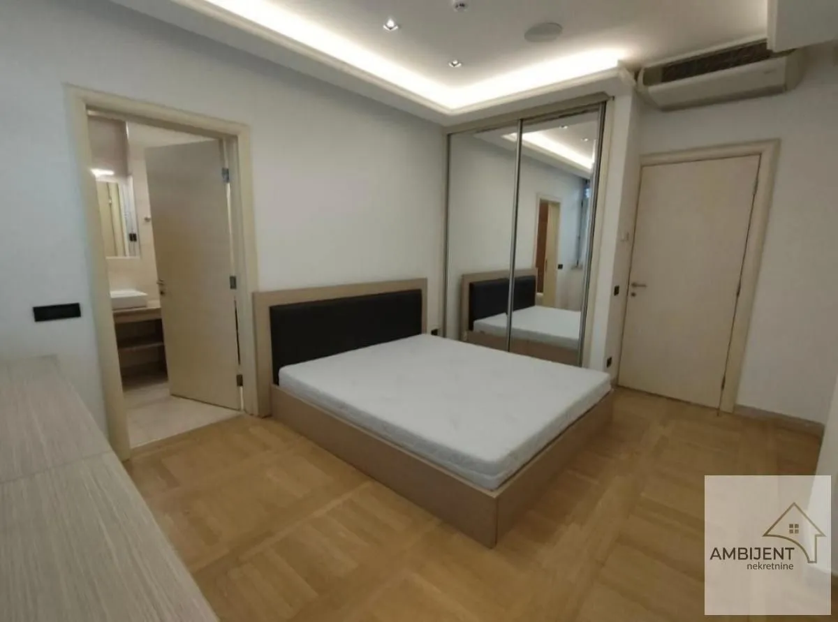 Furnished bedroom with a double bed, built-in wardrobe, and an en-suite bathroom.