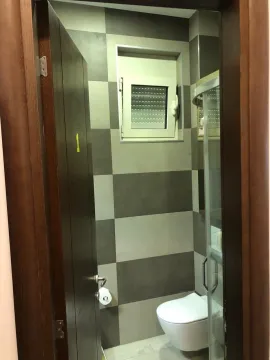 View of a small bathroom with grey and white toned tiles and sanitary ware. - image 18