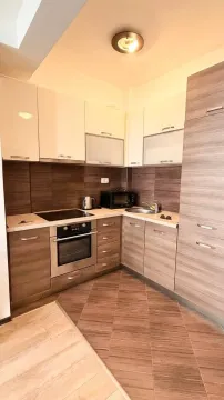 Kitchen equipped with wooden cabinetry and built-in appliances. - image 2