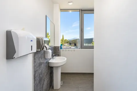 View of the sink and soap dispensers in a modern bathroom with a large window. - image 5