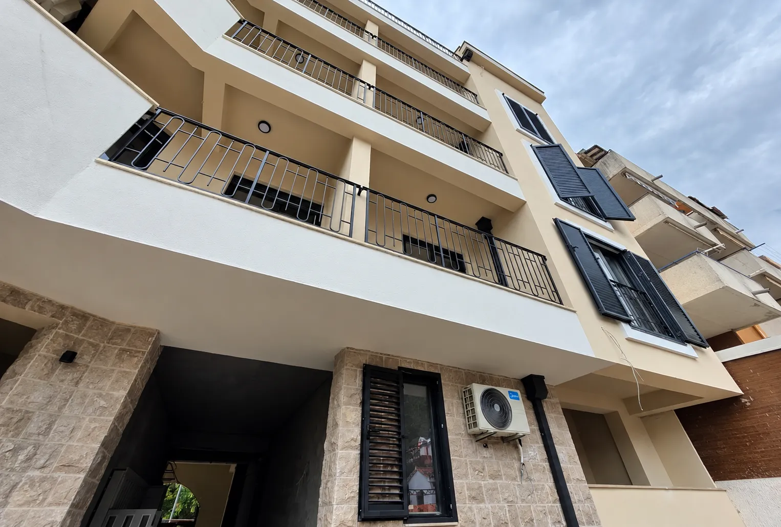 Low-angle view of the residential building facade with balconies.