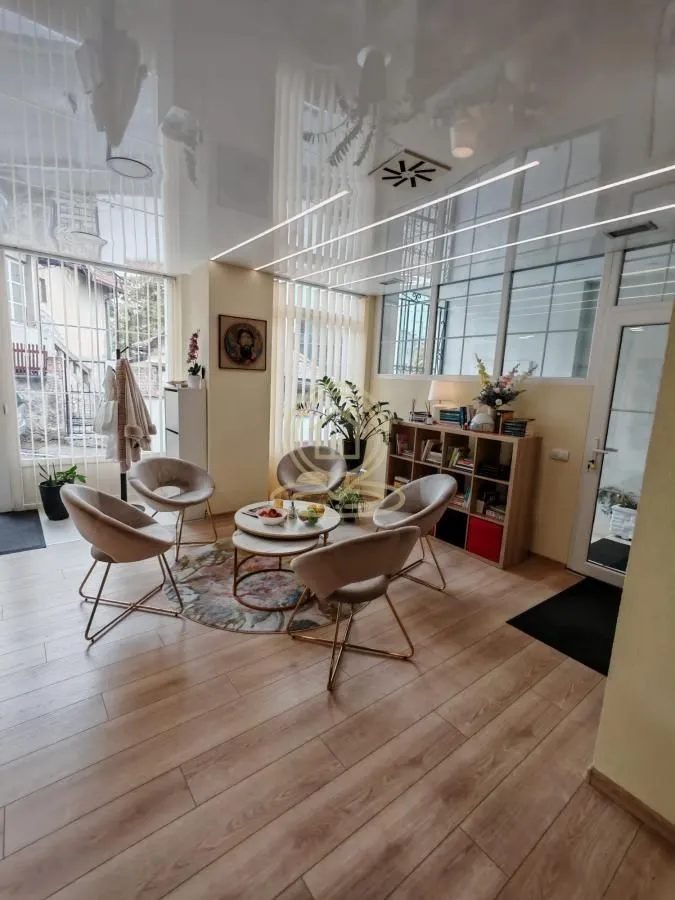 Living room with comfortable armchairs, a coffee table and large windows.