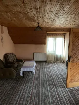 Potkrovlje sa drvenim plafonom, tepihom i garniturom za sedenje. - image 16