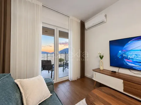 Dnevna soba sa garniturom, TV-om i izlazom na terasu sa pogledom na more. - image 2