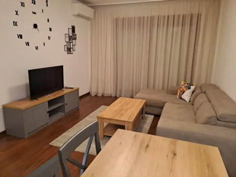 Living room with a corner sofa, television, and dining table. - image 4