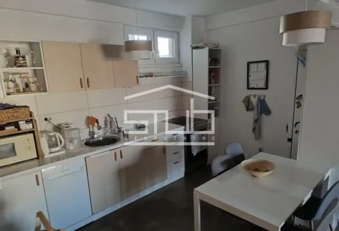 Kitchen with a dining area and built-in white and wood-toned cabinetry. - image 16