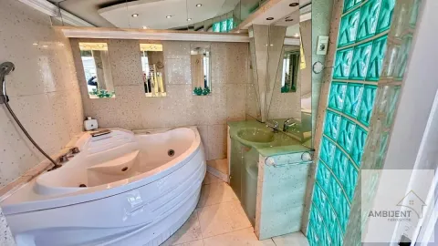 Bathroom with corner bathtub, washbasin, and glass block partition wall. - image 9