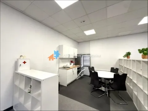 Office kitchen area with a dining table and shelving units. - image 5