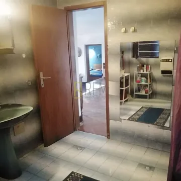 Kupatilo sa umivaonikom, ogledalom i otvorenim vratima prema hodniku. - image 10