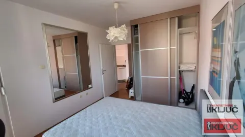 Nameštena spavaća soba sa velikim bračnim krevetom i ugradnim ormarom. - image 7