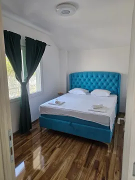 Bedroom with a blue bed and wooden flooring. - image 8
