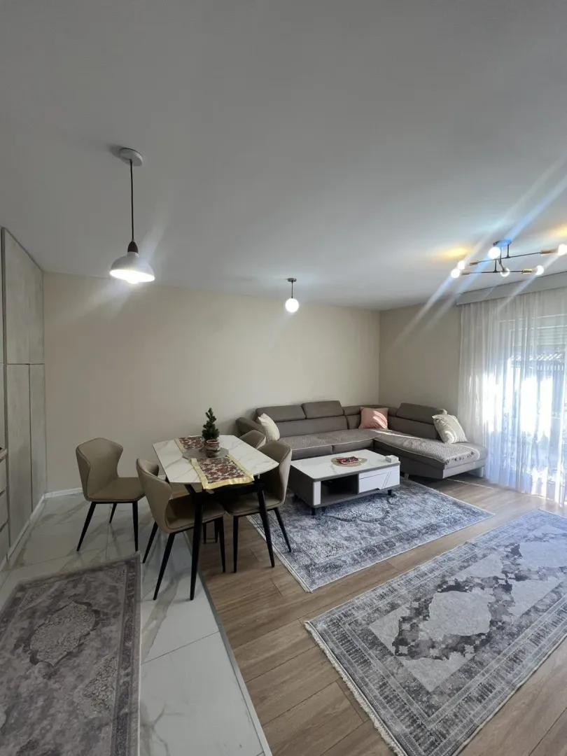 Bright living room with a dining table and a corner sofa.