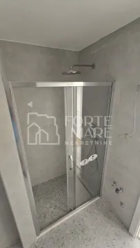 Tuš kabina sa staklenim vratima u popločanom kupatilu. - image 11