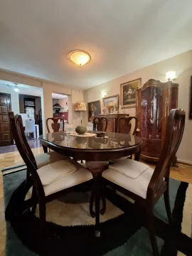 Dining area with a wooden table, chairs, and a traditional-style display cabinet. - image 4