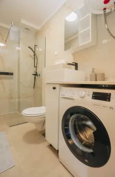 Moderno opremljeno kupatilo sa tuš kabinom i veš mašinom. - image 10