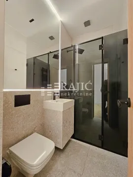 Modern bathroom with a shower cabin, sink, and built-in sanitary ware. - image 7