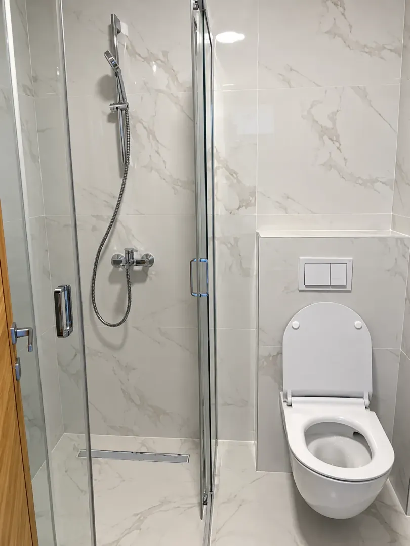 Modernly equipped bathroom with a shower cabin and a toilet.
