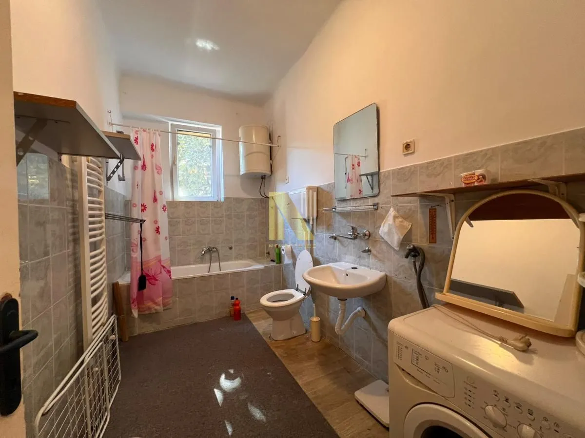 Bathroom with a bathtub, washbasin, toilet, and washing machine.