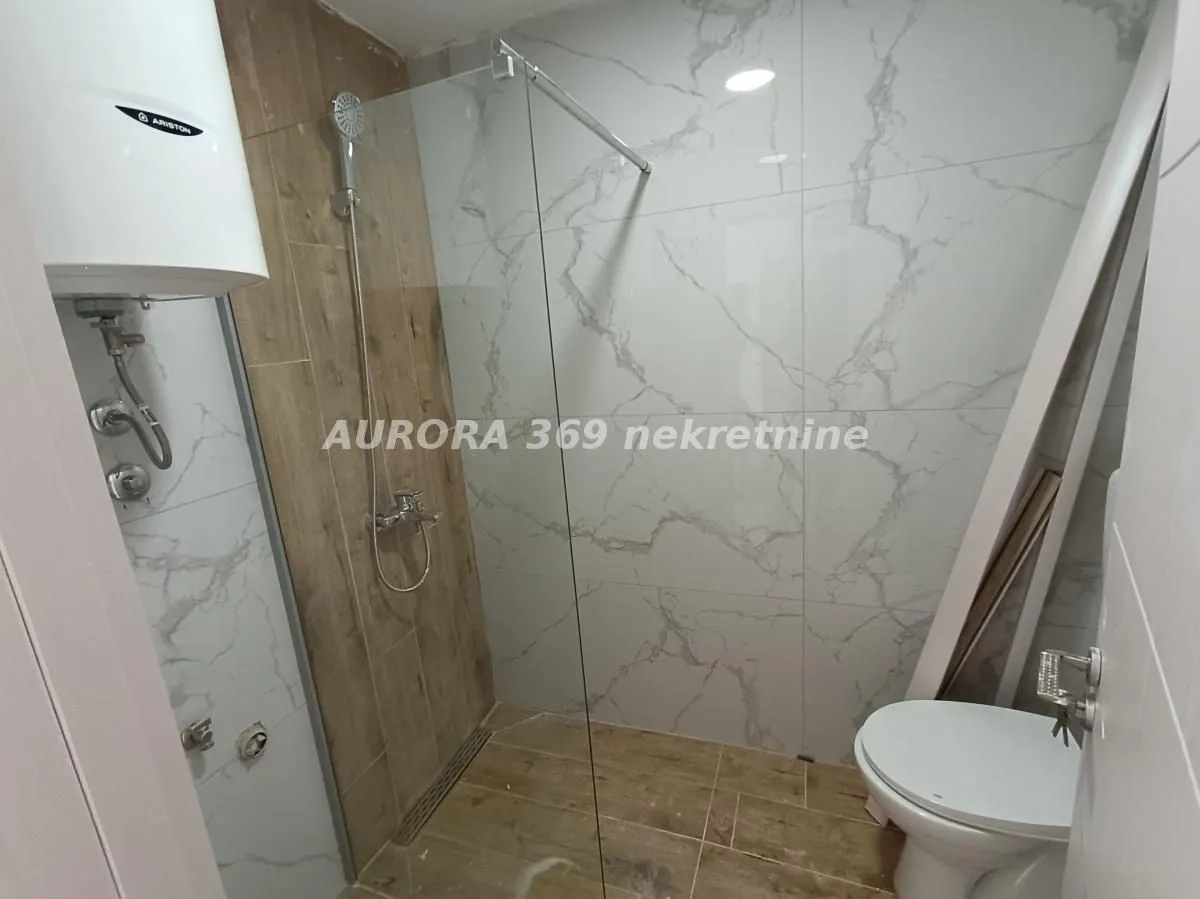 Moderno opremljeno kupatilo sa tuš kabinom i wc šoljom.
