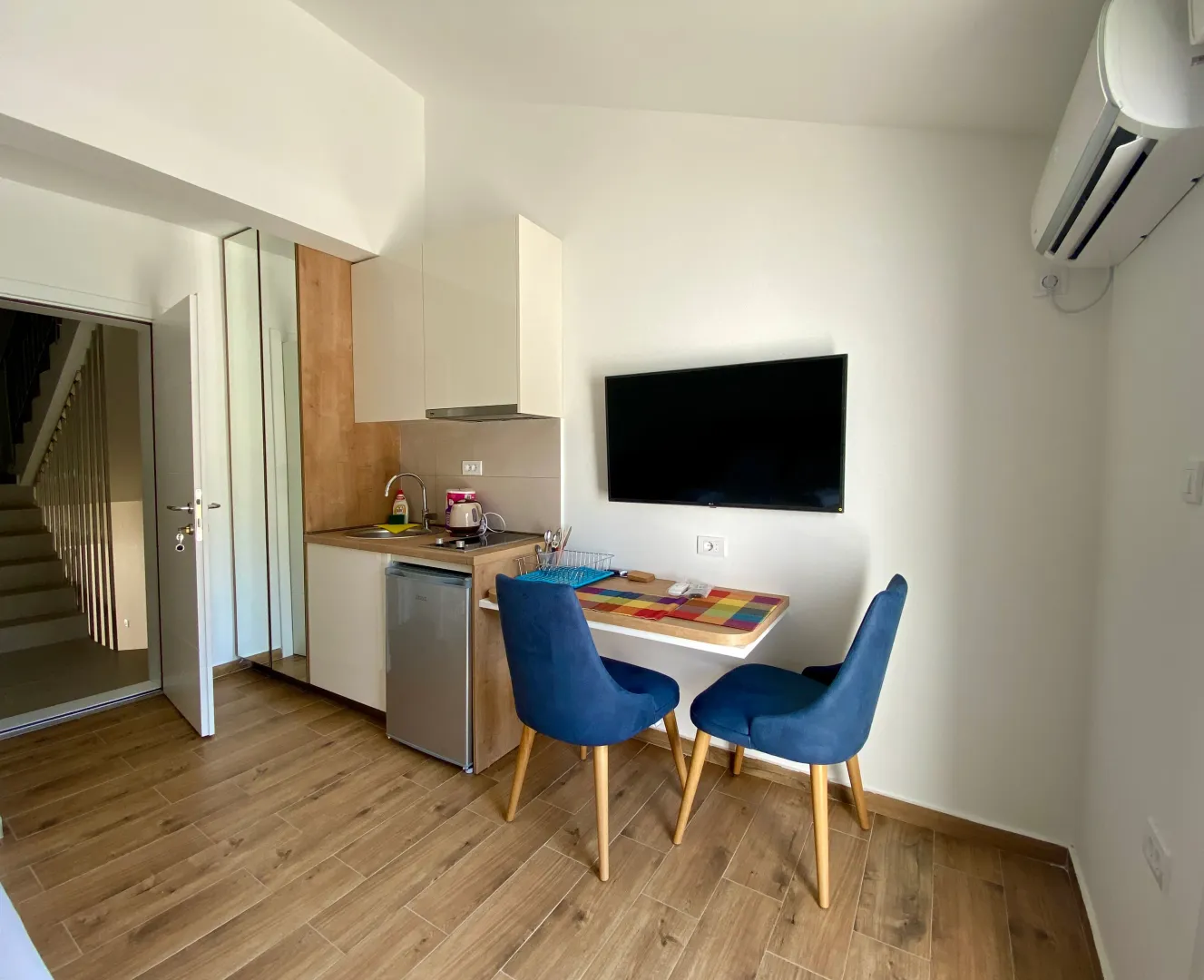 Small kitchen with a dining table and blue chairs.