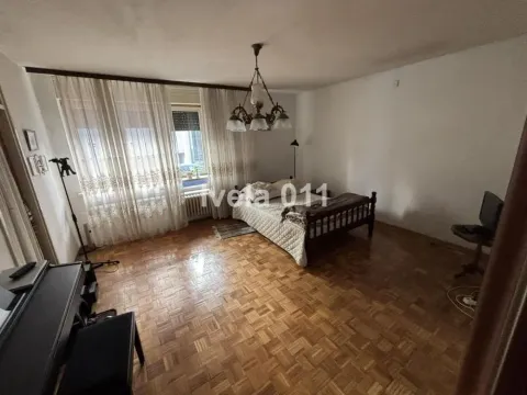Prostrana spavaća soba sa klasičnim drvenim krevetom i parketom. - image 4