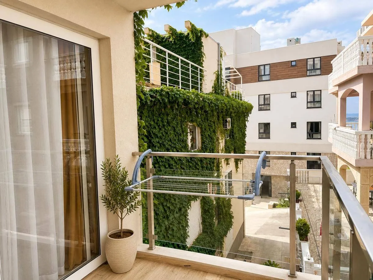 Furnished balcony overlooking surrounding buildings and courtyard.
