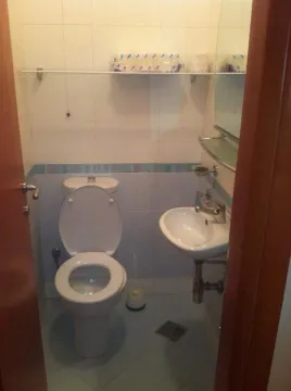 Malo kupatilo sa toaletom i lavaboom, fotografisano kroz otvorena vrata. - image 8