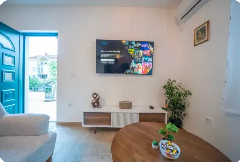 Living room with a TV, TV unit, and seating area. - image 13