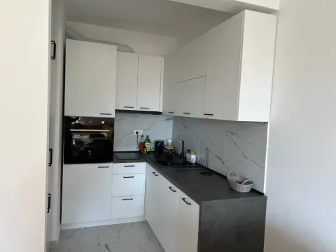 Manja moderna kuhinja sa bijelim elementima i tamnom radnom površinom. - image 13