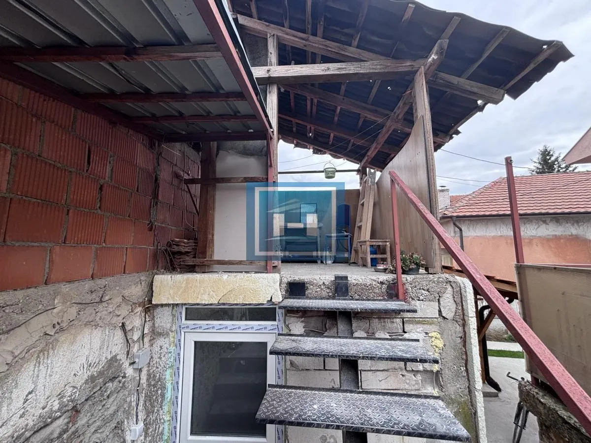 Spoljni dio objekta sa stepenicama i nadstrešnicom u procesu renoviranja.