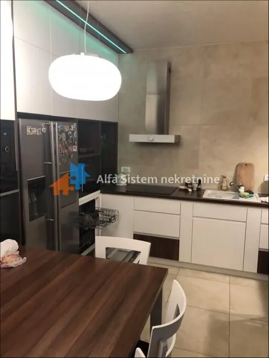 Modern kitchen equipped with white cabinets and a dining table in the foreground.