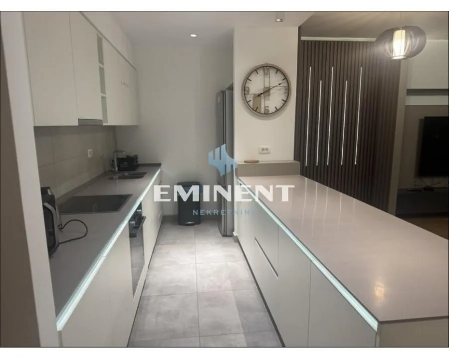 Modern kitchen with white units and a counter.