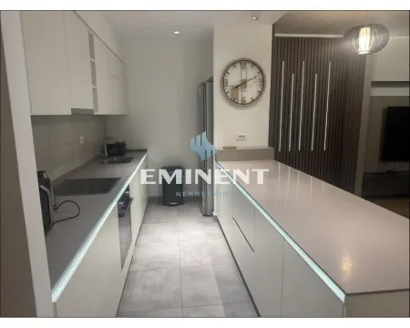 Modern kitchen with white units and a counter. - image 15