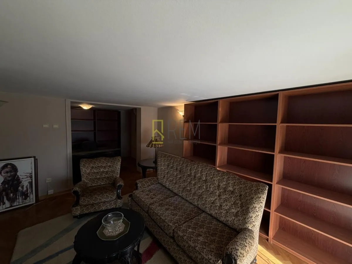 Living room furnished with furniture and wooden shelves.
