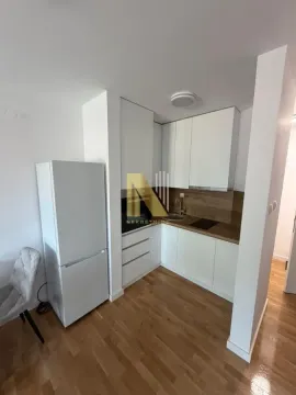 Manja bela kuhinja sa drvenom radnom pločom i frižiderom. - image 9