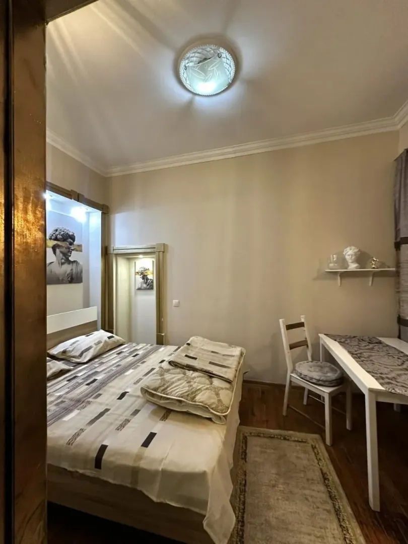 Furnished bedroom with a double bed, desk, and decorative elements.