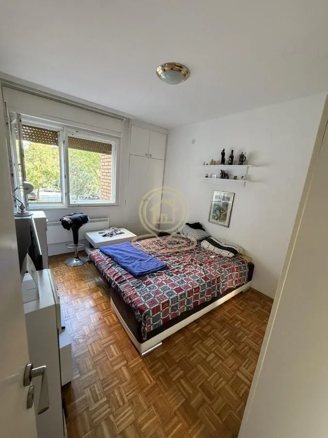 Small bedroom with a bed, wardrobe, and window.