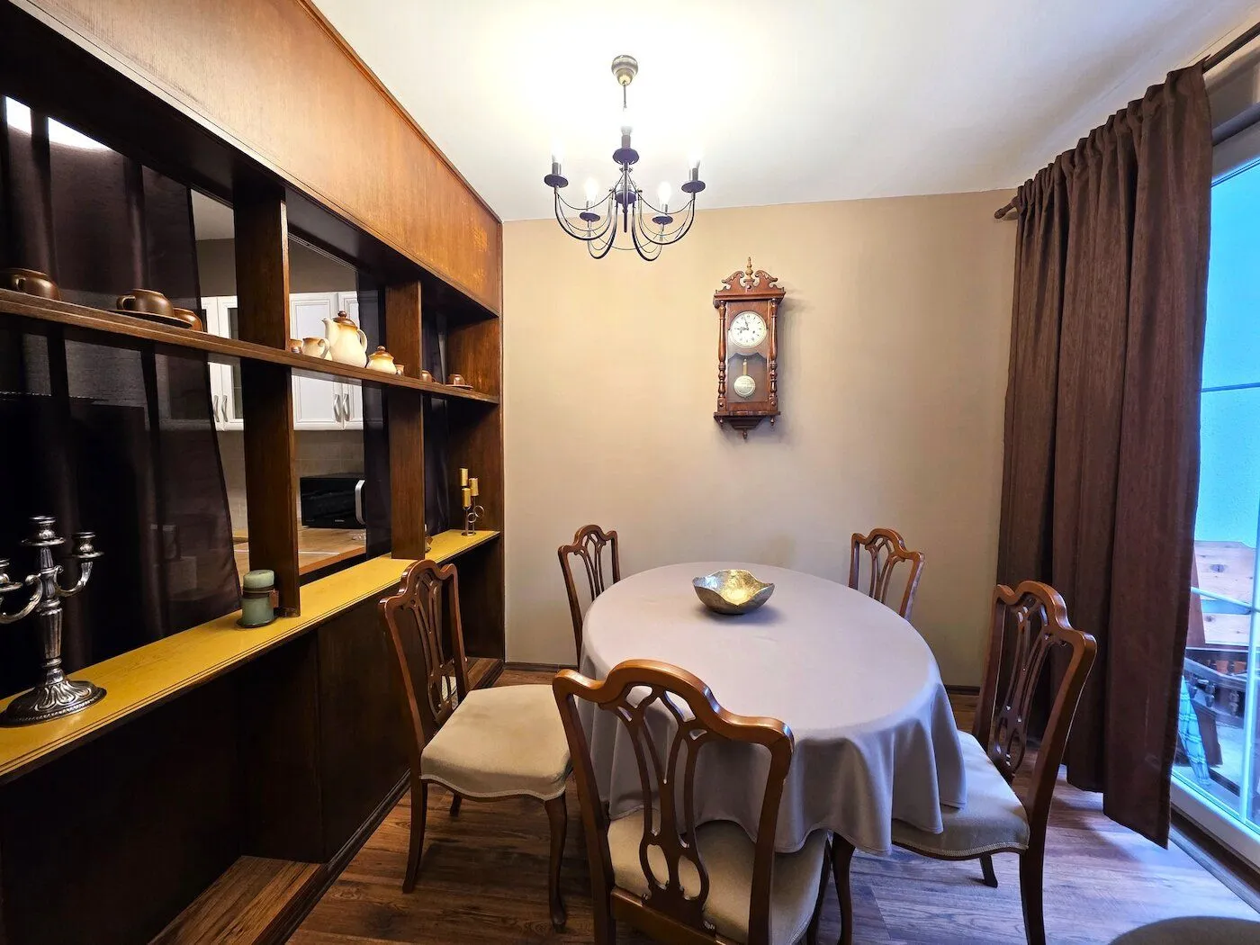 Dining room with a wooden table, chairs, and a wall clock.