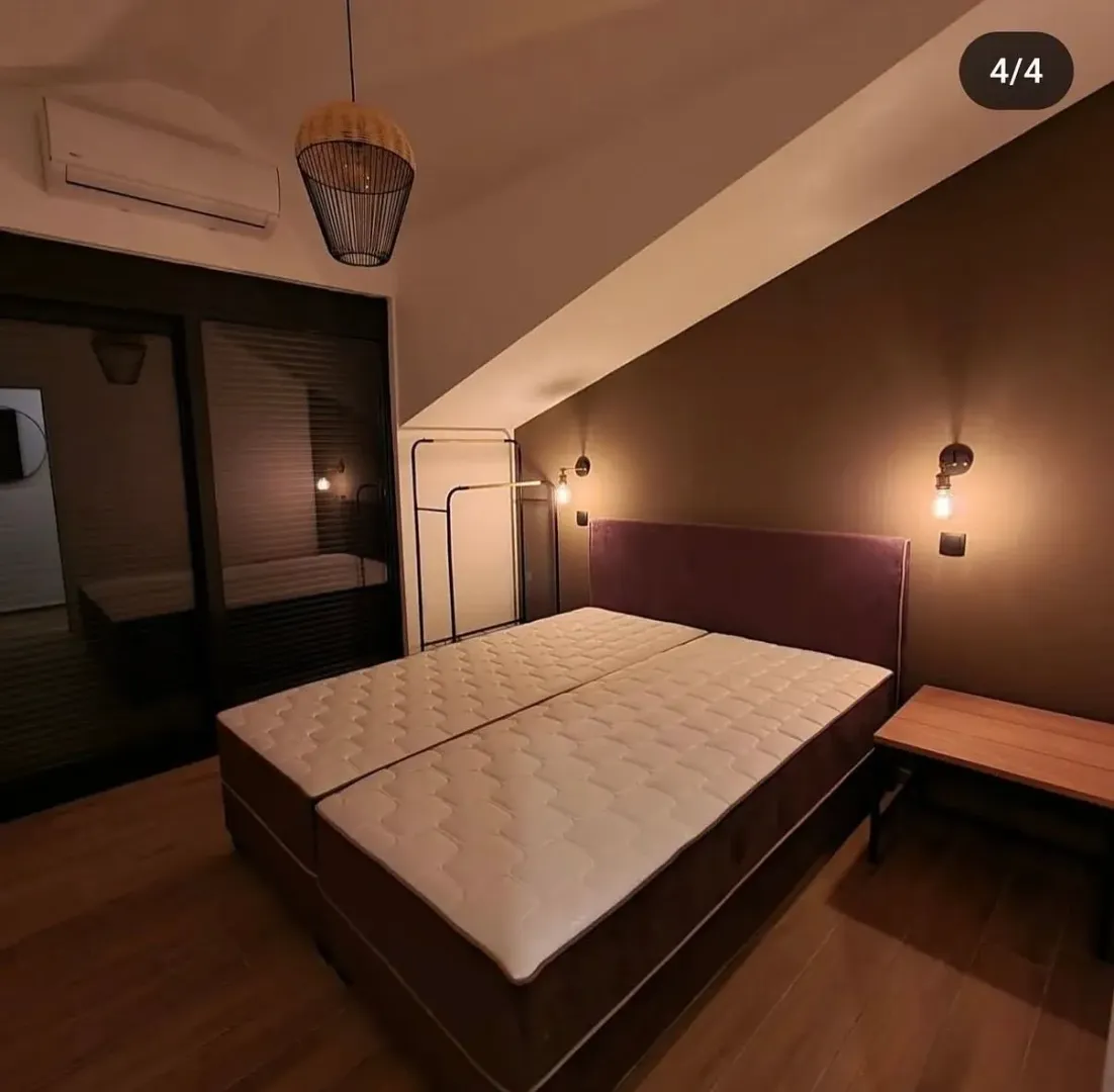 Modern bedroom with a double bed and sloping ceiling.