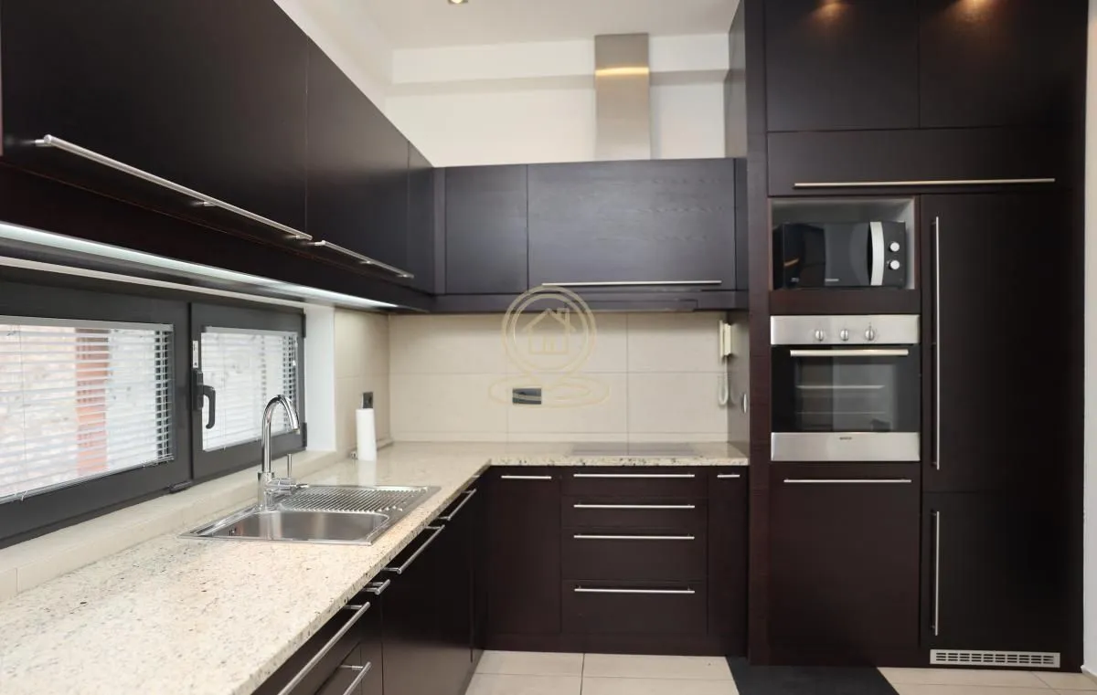 Modern kitchen with dark cabinetry and built-in appliances.