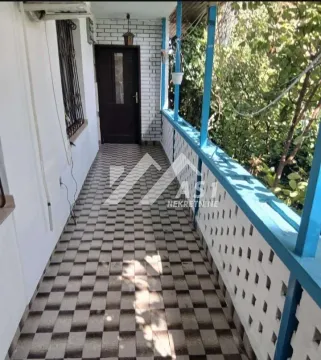 Natkriveni balkon sa popločanim podom i plavom ogradom. - image 8