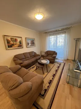Bright living room with a brown seating set, a rug, and paintings on the wall. - image 3
