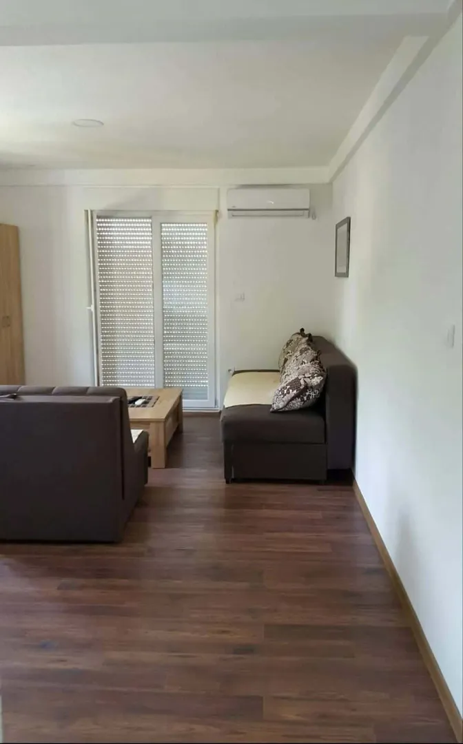 Dnevna soba sa garniturom i izlazom na terasu.