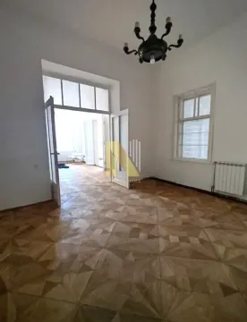 Prazna prostorija sa parketom i otvorenim vratima koja vode u drugu sobu. - image 16