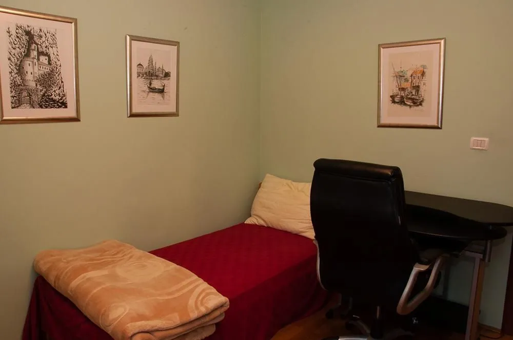 A small bedroom featuring a single bed and a study desk.