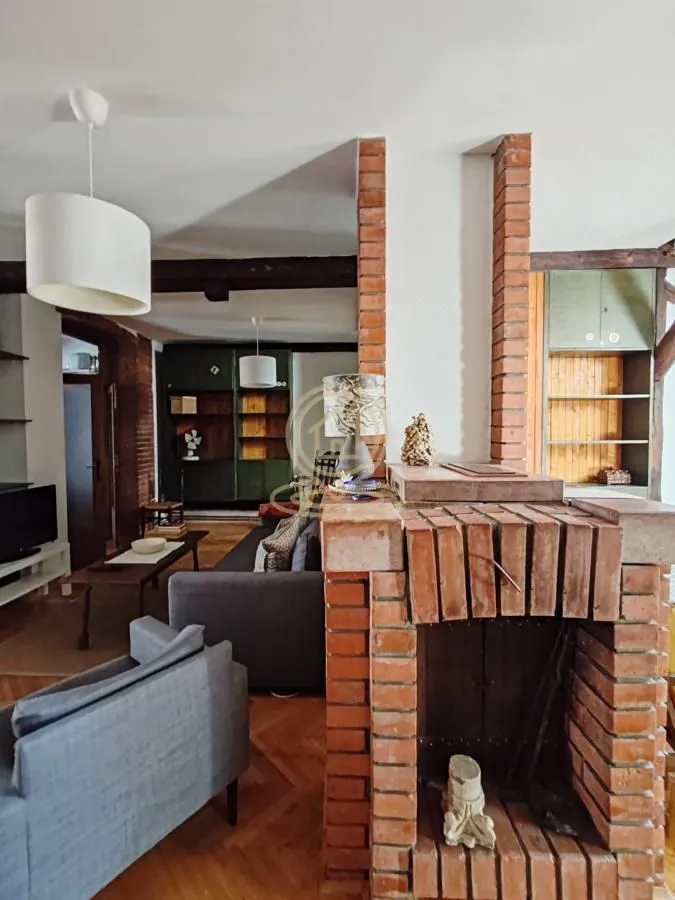 Living room with a brick fireplace and wooden furniture.
