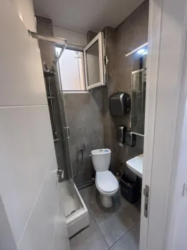 Smaller bathroom with a shower cabin, toilet, and sink. - image 5
