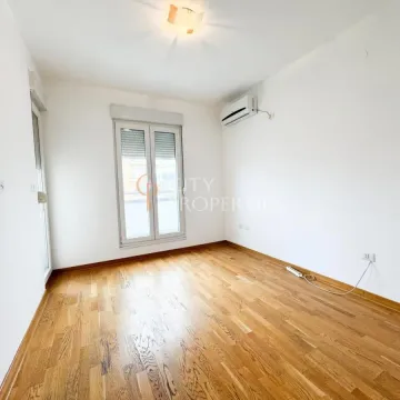 Empty room with wooden flooring, air conditioning unit, and a window. - image 7