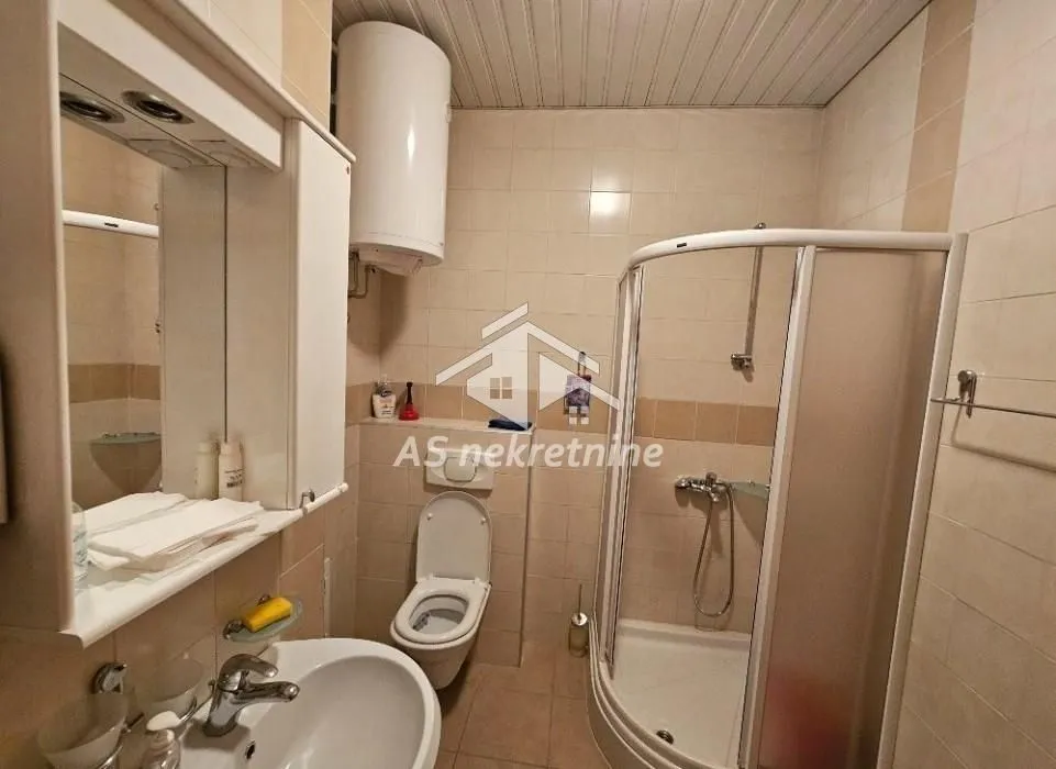 Kupatilo opremljeno tuš kabinom, umivaonikom i wc šoljom.